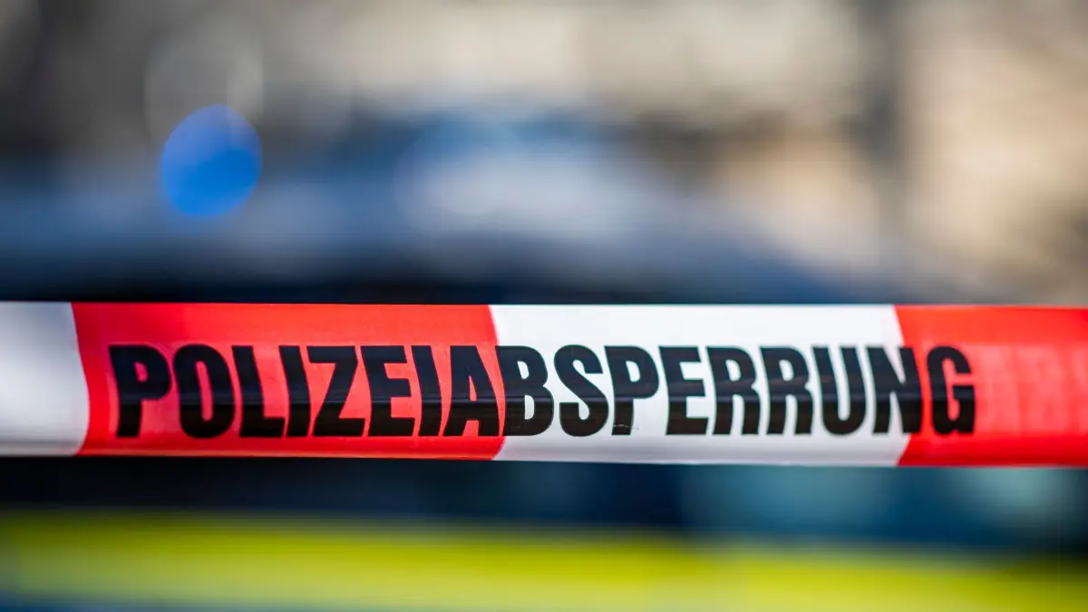 Absperrung der Polizei: ARCHIV - 28.09.2021, Nordrhein-Westfalen, Gütersloh: Ein Absperrband mit der Aufschrift «Polizeiabsperrung» ist vor einem Polizeiwagen aufgespannt. (zu dpa: «Getränkewagen klemmt Mann in Aufzug ein – 26-Jähriger stirbt») Foto: David Inderlied/dpa +++ dpa-Bildfunk +++