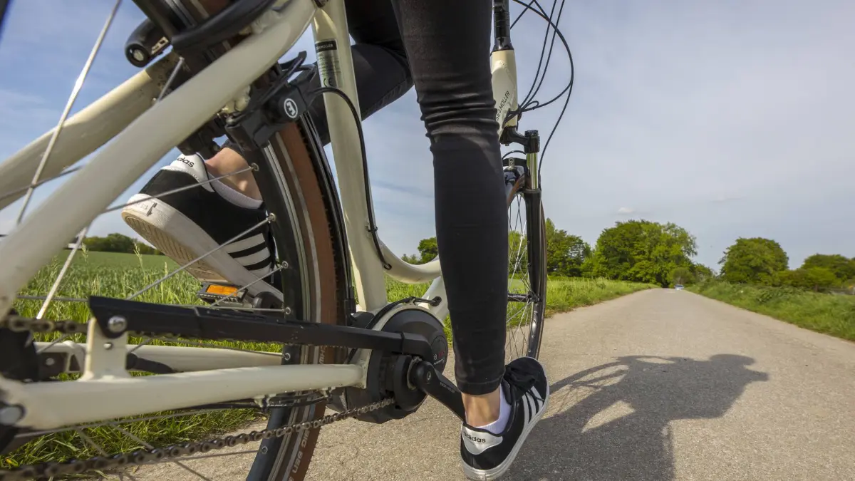 Junge Frau fährt mit einem E-Bike, Elektro Fahrrad, durch einen Elektromotor unterstütztes Fahren, Akku, *** Young woman rides an electric bike assisted by an electric motor assisted battery