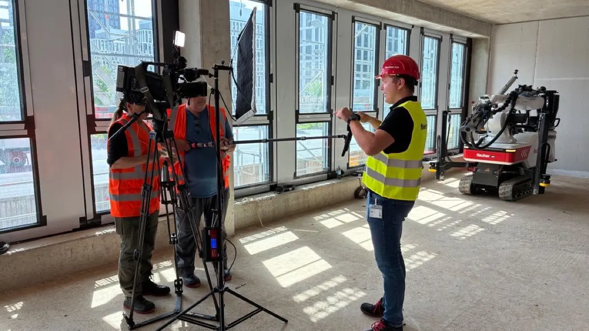 Fischer-Geschäftsführer Matthias Schneider gibt n-tv ein Interview. Im Hintergrund der Fischer-Baubot.
