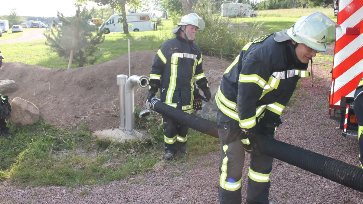 Mit Schnellverschlüssen schließen die Wehrmänner (Stephan Demattio, Wilfried Hepting) das Unterbränder Fahrzeug blitzschnell an den unterirdischen 25000-Liter-Tank an.