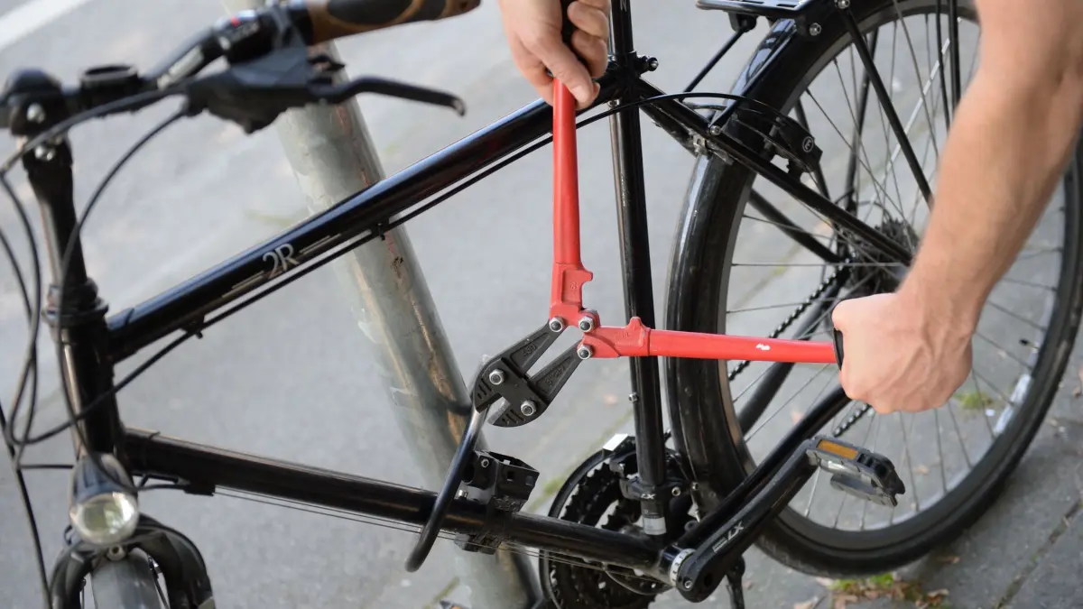 Fahrraddiebstahl: ARCHIV - 14.09.2016, NA, München: ILLUSTRATION - Ein Mann versucht mit einem Bolzenschneider ein Fahrradschloss aufzubrechen (gestellte Szene). (zu dpa: ««Kleine Helden von Osnabrück»: Elfjährige fassen Fahrraddieb») Foto: Andreas Gebert/dpa +++ dpa-Bildfunk +++