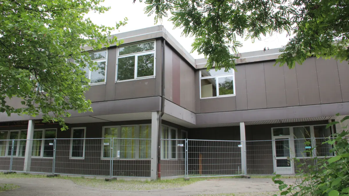 Das Bestandsgebäuder der Hallerhöhe ist inzwischen von Bauzäunen umgeben. Wann die Generalsanierung starten kann, ist aber noch nicht klar.