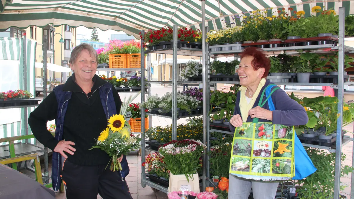 Blumenhändlerin ??? und ihre Kundin finden: Auf dem Wochenmarkt kauft man für "Leib und Seele" ein.