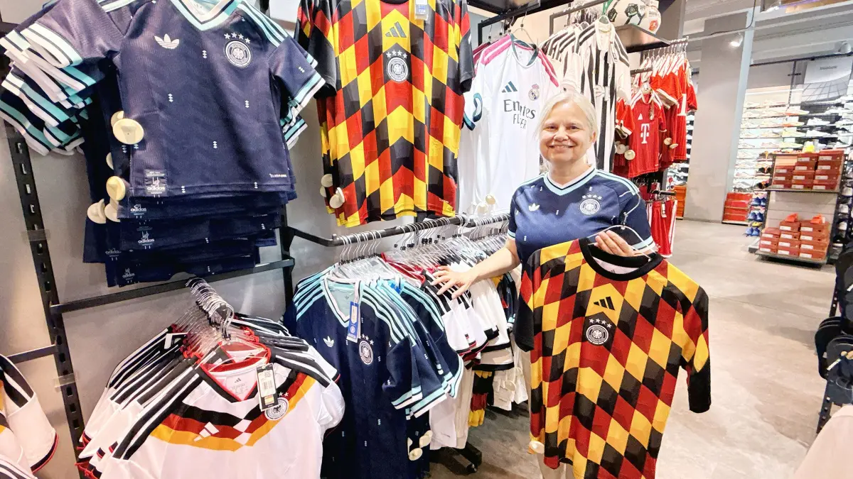 Dorothee Friederichs vor der Trikotwand von Intersport Kirsner in Rottweil. Sowohl die blauen Trikots als auch die Aufwärmtrikots sind derzeit heiß begehrt.