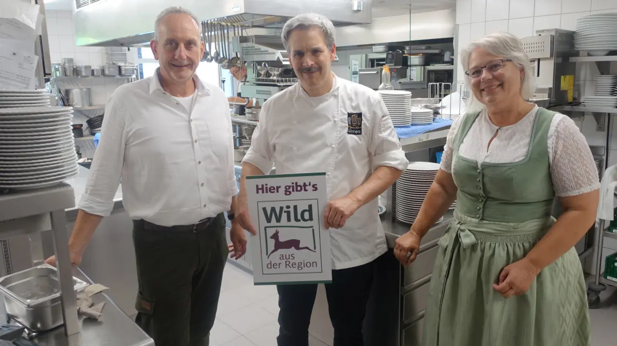 Claus Weitbrecht (Mitte) nimmt in seiner Gourmetküche das Label "Wild aus der Region" von Kreisjägermeisterin Elke Marko und Hegeringleiter Oliver Kugel entgegen.