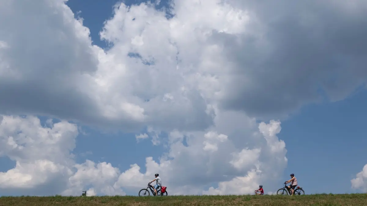 Sommer in Baden-Württemberg: 22.06.2026, Baden-Württemberg, Welzheim: Eine Gruppe Radfahrer fahren durch die Sonne. Wolken sind in der Nähe des Aichstruter Stausees am Himmel zu sehen. Foto: Marijan Murat/dpa +++ dpa-Bildfunk +++