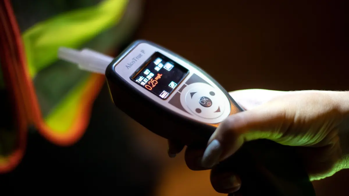 Alkoholkontrolle: ARCHIV - 10.07.2019, Bayern, München: Eine Polizistin kontrolliert mit einem Atemalkoholtest einen Verkehrsteilnehmer. (zu dpa: «Polizei stoppt 140 Alkohol- und Drogenfahrten in Thüringen») Foto: Sina Schuldt/dpa +++ dpa-Bildfunk +++