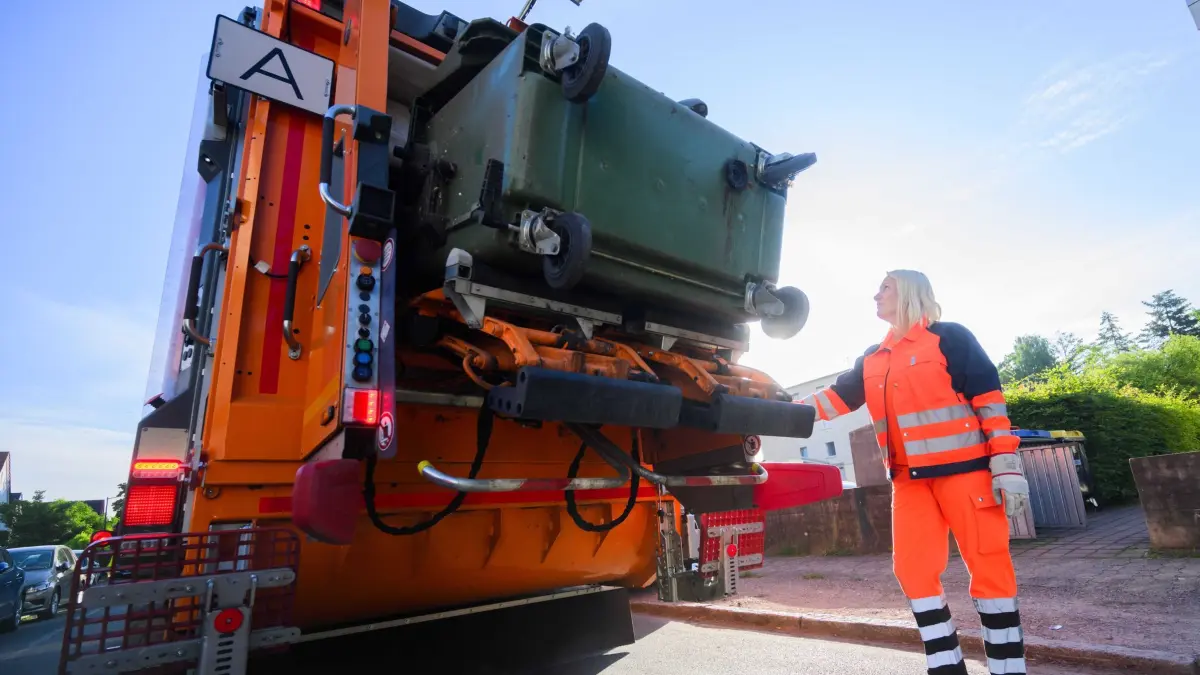 Müllabfuhr: ARCHIV - 10.06.2024, Niedersachsen, Langenhagen: Yvonne Pedd, Müllwerkerin beim aha Zweckverband Abfallwirtschaft Region Hannover, entleert eine Restmülltonne in ein Müllfahrzeug. (zu dpa: «Reaktion auf Hitzewelle: Müllabfuhr startet früher») Foto: Julian Stratenschulte/dpa +++ dpa-Bildfunk +++