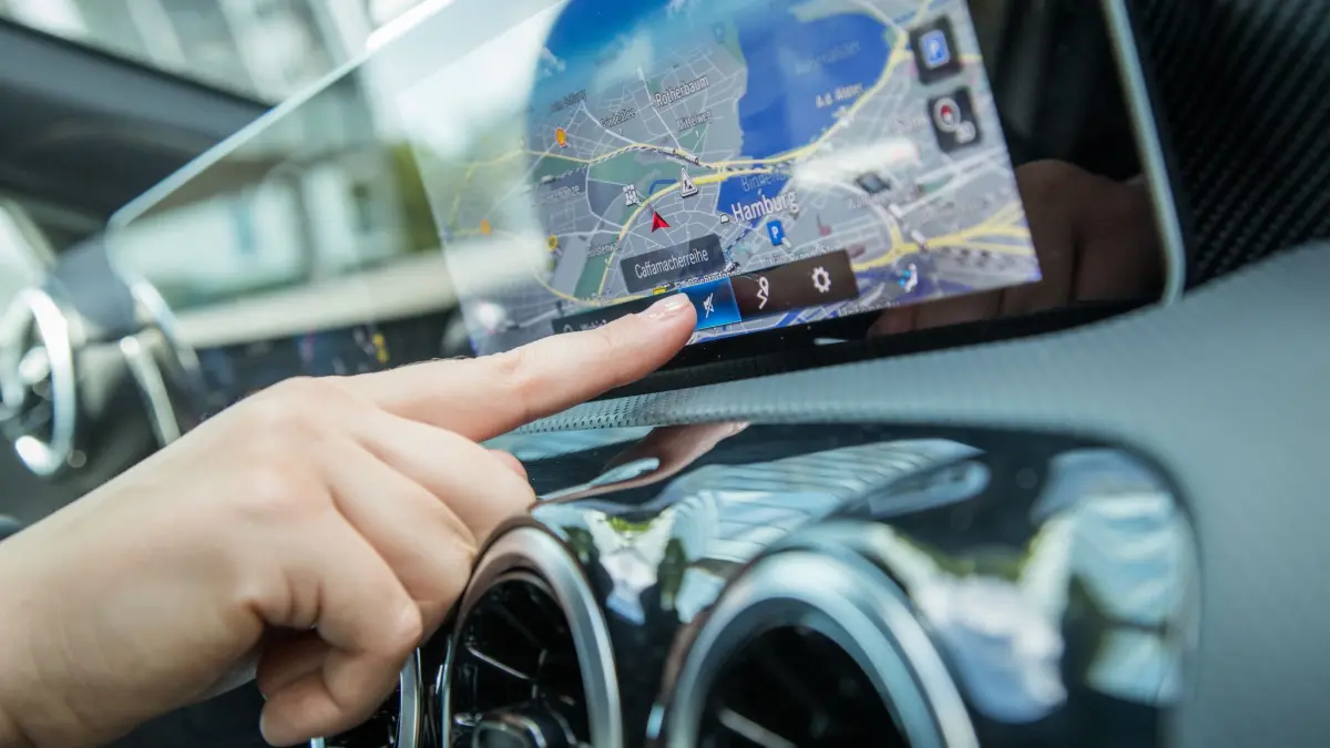 Ein Navigationssystem in einem Auto wird bedient: ILLUSTRATION - Navi als intelligenter Reiseplaner: Längst vorbei die Zeiten, als zusätzlicher Stress aufkam, weil der Beifahrer das Kartenmaterial auf dem Schoß nicht richtig lesen konnte. (zu dpa: «Reiseverkehr: So kommen Autofahrer entspannter ans Ziel») Foto: Christin Klose/dpa-tmn - Honorarfrei nur für Bezieher des dpa-Themendienstes +++ dpa-Themendienst +++