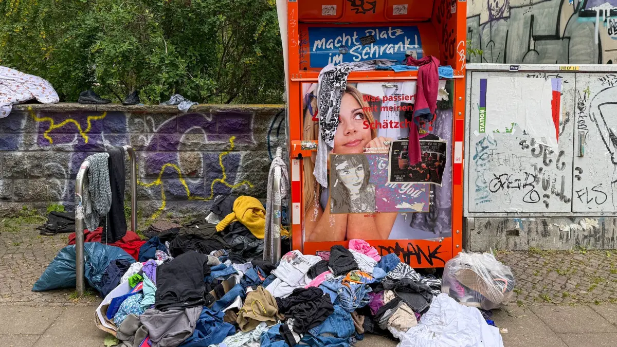 Müll am Kleidercontainer: ARCHIV - 05.05.2025, Sachsen, Leipzig: Aufgerissene Müllsäcke und wild umhergeworfene Kleidung liegen vor einem Altkleidercontainer. (zu dpa: «Deutschland fordert mehr Regeln für Fast Fashion Firmen») Foto: Jan Woitas/dpa +++ dpa-Bildfunk +++
