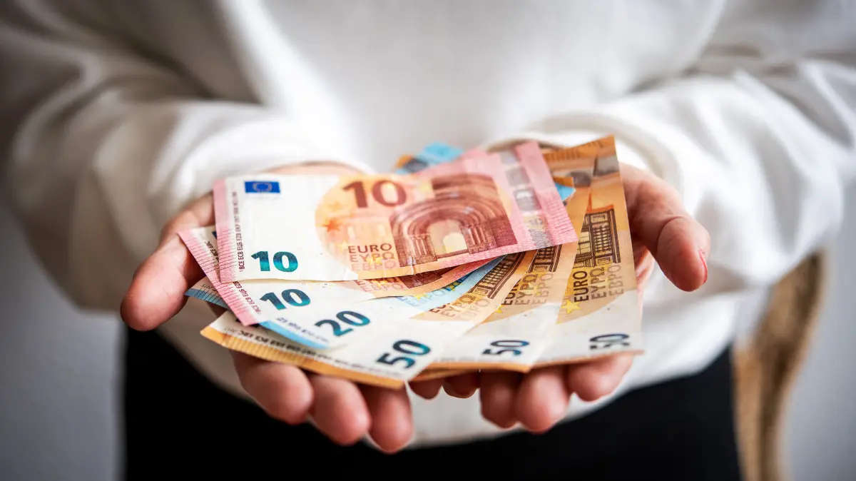 Eine Person hält Geldscheine in den Händen. Kurz vor Weihnachten spenden viele Menschen Geld. (zu dpa: «Wer Bedürftige beschenken will, hat viele Möglichkeiten») +++ dpa-Bildfunk +++