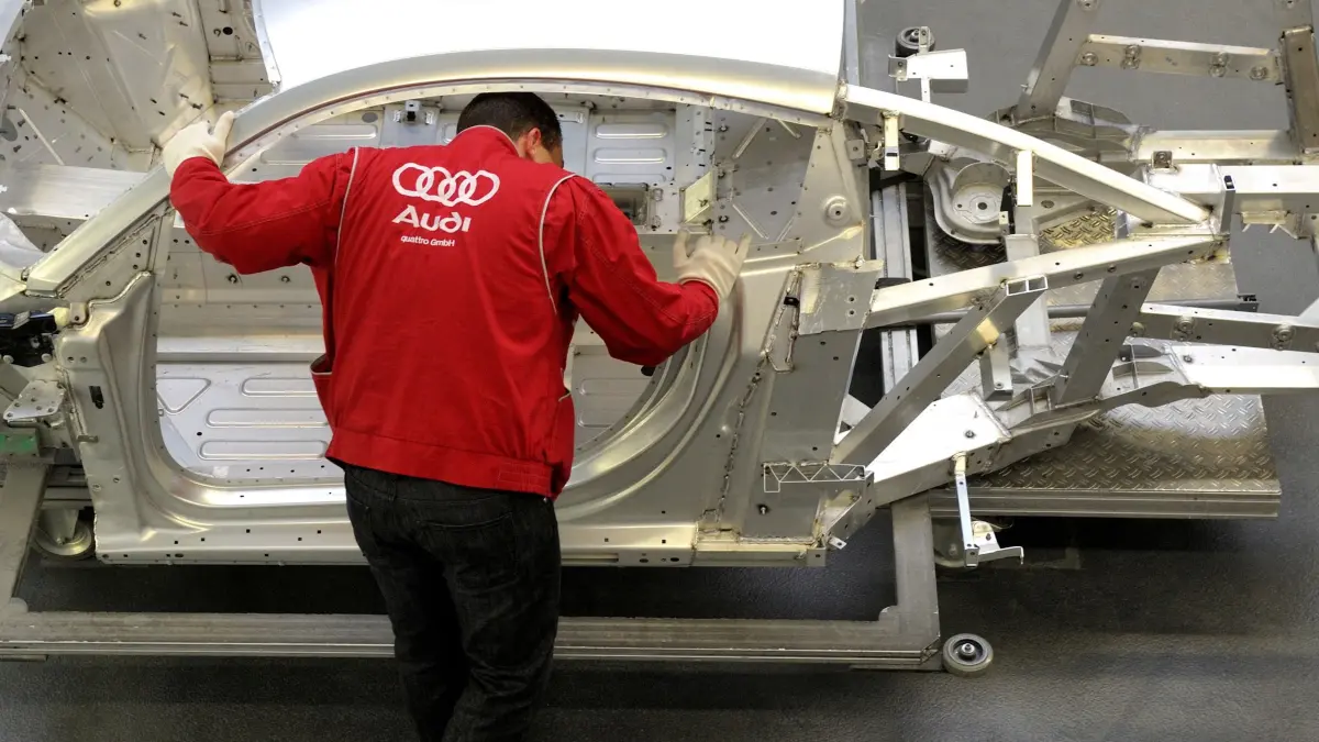 FILES-GERMANY-LABOUR-AUTOMOBILE-VW: (FILES) An employee of German luxury car maker Audi works on an Audi R8 sportscar at an assembly line of the Audi plant in Neckarsulm, southwestern Germany, on February 15, 2012. According to a media report on June 26, 2026, the car manufacturer Volkswagen plans to cut up to 100,000 jobs. Four plants in Germany, including the Audi plant in Neckarsulm, are to be closed, the "Manager Magazin" reported, citing insiders. In addition, VW CEO Oliver Blume is reportedly planning to spin off the core Volkswagen brand into a new company. According to the report, the job cuts are planned worldwide. (Photo by THOMAS KIENZLE / AFP)