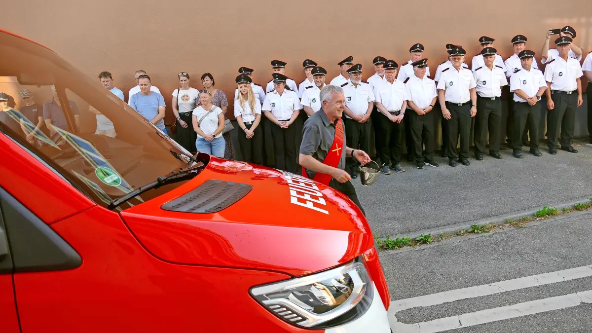 Diakon Herbert Bintert weiht während einer kleinen Feier den neuen Mannschaftstransportwagen der Feuerwehr Pfohren ein