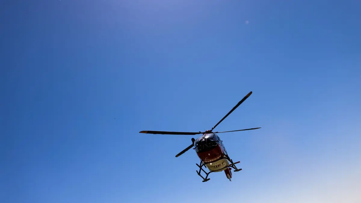 DRF Luftrettung trainiert Windenrettung: ARCHIV - 23.04.2021, Baden-Württemberg, Ihringen: Ein Helikopter der DRF Luftrettung landet auf dem leeren Parkplatz eines Ausflugslokals. Für eine zügige und schonende Rettung aus unzugänglichen Gebieten ist der Hubschrauber mit einer fest installierten Winde ausgestattet, die DRF Luftrettung trainiert den Einsatz der Winde und die Zusammenarbeit mit der Bergwacht am Kaiserstuhl nahe Freiburg. (zu dpa: «Seniorin stürzt etwa 50 Meter Böschung hinab - Lebensgefahr») Foto: Philipp von Ditfurth/dpa +++ dpa-Bildfunk +++