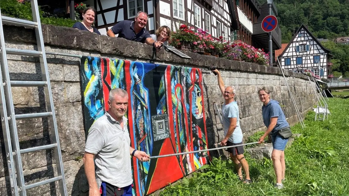 Die Künstlergruppe beim Hängen der Bilder an der Bachmauer der Schiltach.Suzanne Kraus, Detlev Trentau, Claudia BaumgartnerMichael Baumgartner, Alfred Dieterle, Martina Dieterle