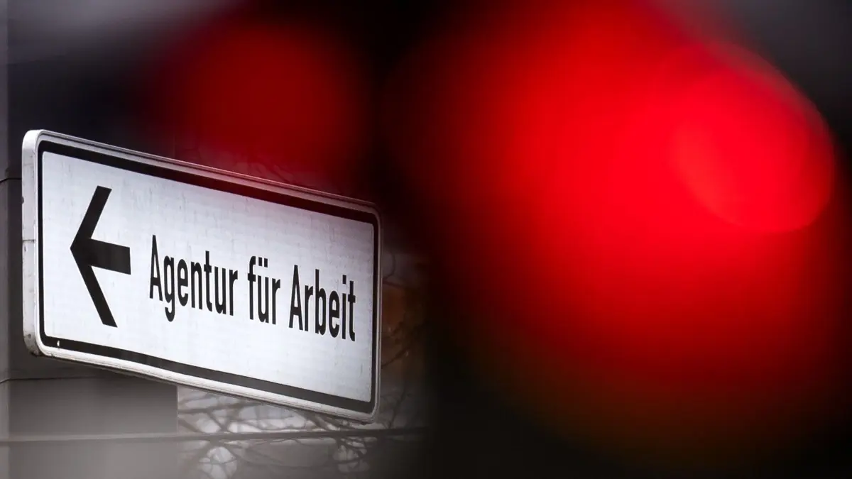 Jobcenter: ARCHIV - 30.03.2020, Bremen: Eine rote Ampel leuchtet vor einem Schild, das auf die Agentur für Arbeit hinweist. (zu dpa: «Etwas mehr Arbeitslose in Rheinland-Pfalz») Foto: Sina Schuldt/dpa +++ dpa-Bildfunk +++