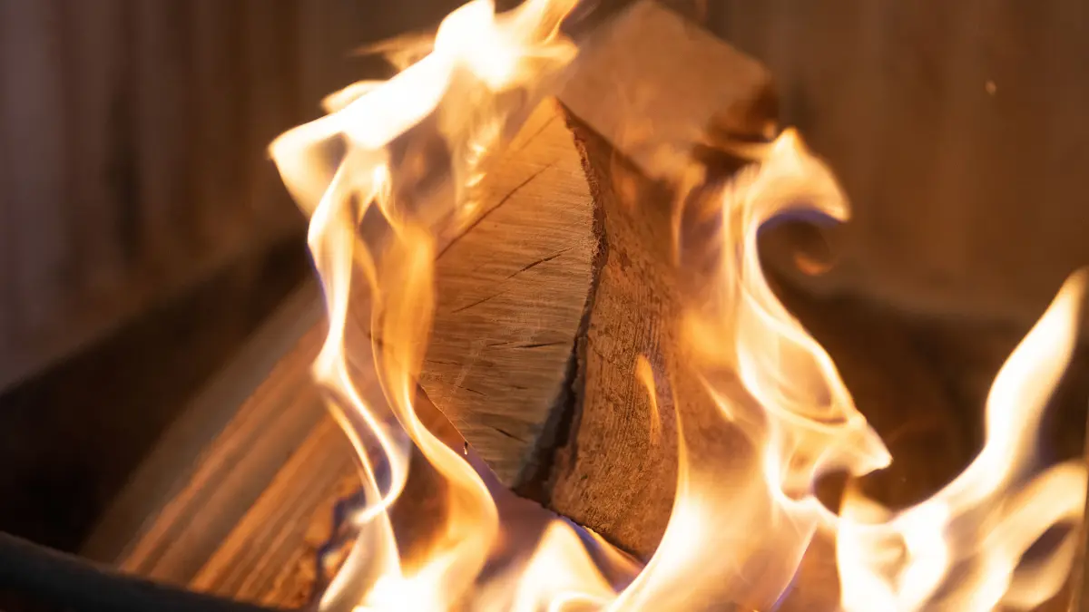 PRODUKTION - 19.12.2022, Hessen, Frankfurt/Main: Holzscheite brennen in einem Ofen, der dazu genutzt wird, eine Wohnung zu heizen. Die Preise für Brennholz sind im letzten Jahr stark gestiegen. Foto: Sebastian Gollnow/dpa +++ dpa-Bildfunk +++
