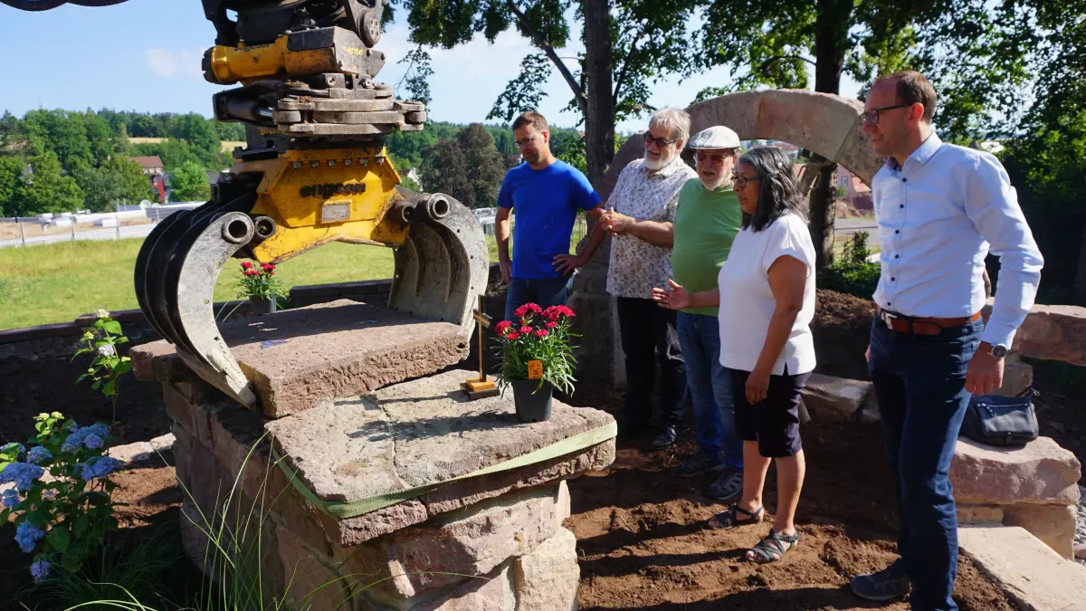 Das Alte Friedhof in Schömberg hat jetzt sogar einen Altar bekommen. Darüber freuen sich Stefan Bertsch (von links), Bernd Brandl und Roland Helber von der Evangelischen, Rosario Moser von der Katholischen Kirchengemeinde und Schömbergs Bauamtsleiter Martin Dittler. Pirmin Killinger setzte mit dem Bagger den letzten Stein auf den Altar.