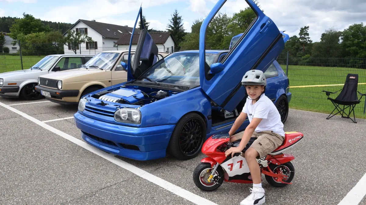 Mini Motorrad versus Edel-Car mit Flügeltüren.