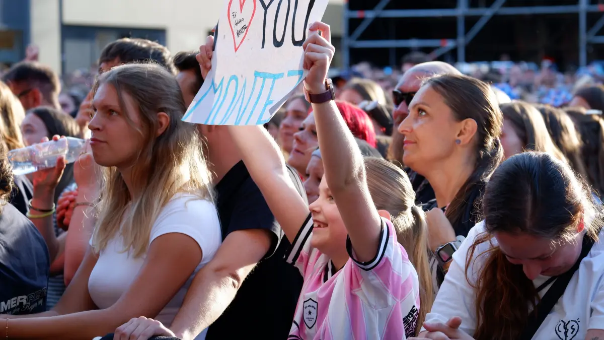 Eine Liebeserklärung an den Künstler: "Ich liebe dich, Montez", steht auf dem Schild, dass das Mädchen in die Höhe hält.