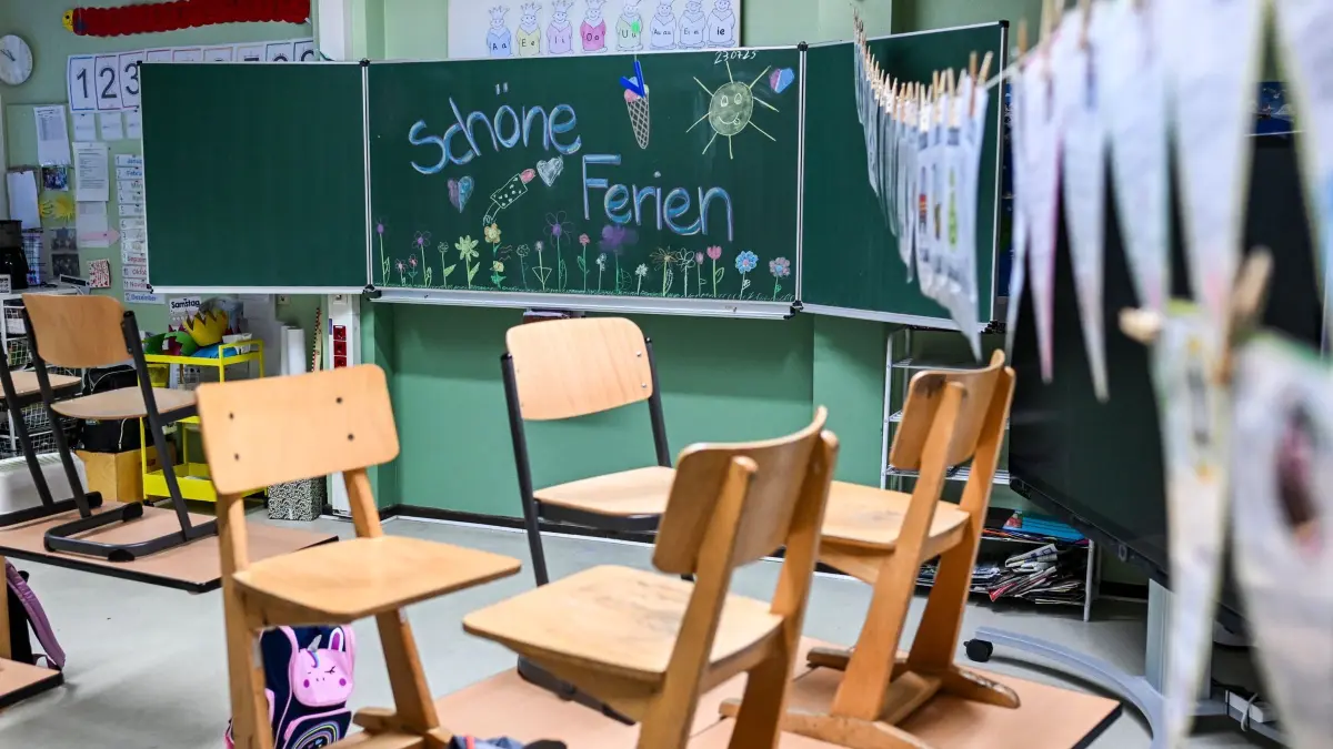 Ferienstart: ARCHIV - 23.07.2025, Berlin: Hochgestellte Stühle und eine bemalte Tafel und den Worten „Schöne Ferien“ in einer Schule am letzten Schultag vor den Sommerferien. (zu dpa: «Urlaub vor dem Ferienstart? Schulschwänzen kann teuer werden») Foto: Jens Kalaene/dpa +++ dpa-Bildfunk +++