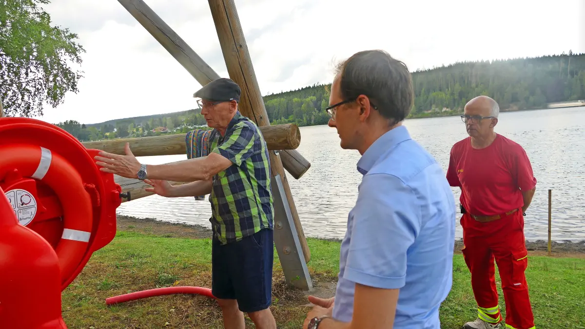 Ortsvorsteher Lutz Rademacher (von links) erläutert Bürgermeister Micha Bächle die Verwendung des Rettungsrings. DLRG-Einsatzleiter Norbert Dietrich hört aufmerksam zu.