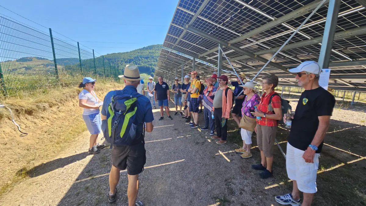 Im Schatten der Panels informierte Klimaschutzmanagerin Anna-Magdalena Hoffmann, links, vor interessierten Besuchern über die Effizienz des steilsten deutschen Solarparks in Fröhnd.