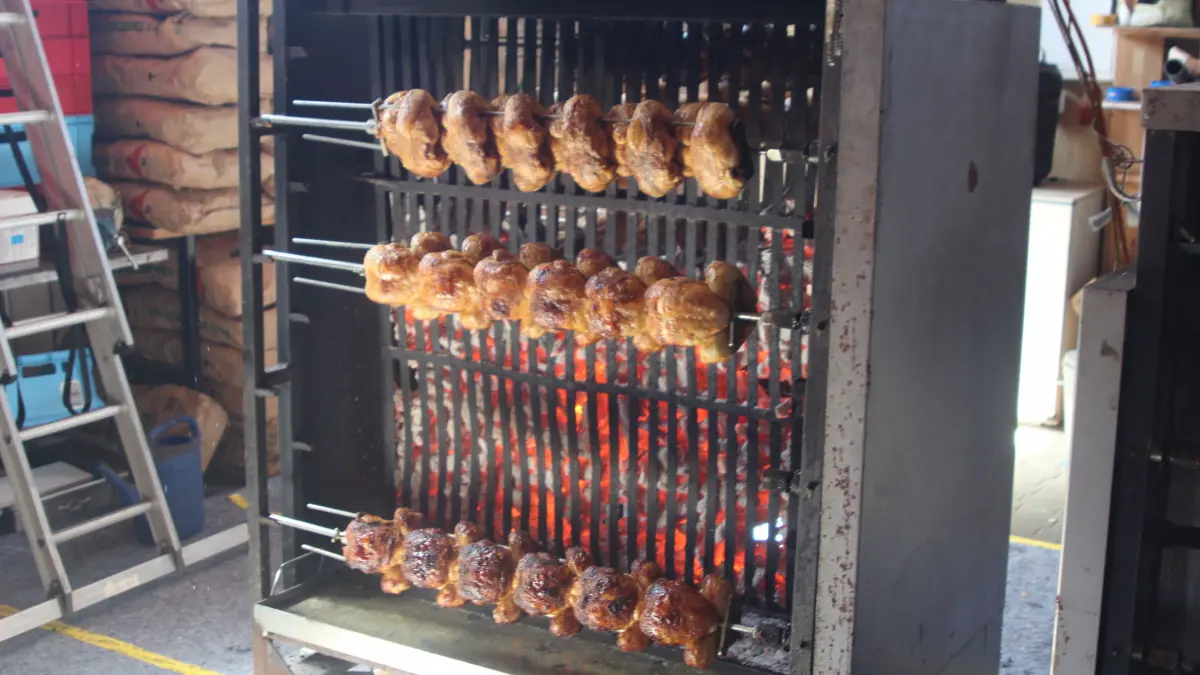 Knusprige Hähnchen am glühenden Holzkohlegrill - die Spezialität des Festes
