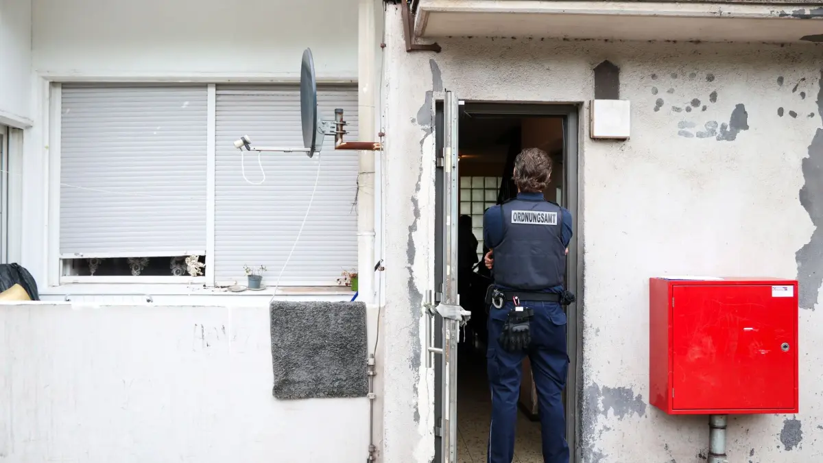 Kontrollaktionen in mehreren NRW-Städten: 09.07.2026, Nordrhein-Westfalen, Duisburg: Ein Mitarbeiter vom Ordnungsamt der Stadt Duisburg steht im Eingangsbereich zu einem Wohnhaus, in dem eine Kontrollaktion stattfindet. In mehreren Städten von Nordrhein-Westfalen fanden Kontrollaktionen gegen Sozialmissbrauch und Geschäften mit Schrottimmobilien statt.xxx (zu dpa: «Problemimmobilien und Sozialbetrug: Kontrollaktion in NRW») Foto: ---/dpa +++ dpa-Bildfunk +++