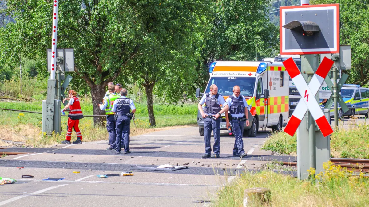 Einsatzkräfte sichern die Unfallstelle am Bahnübergang.