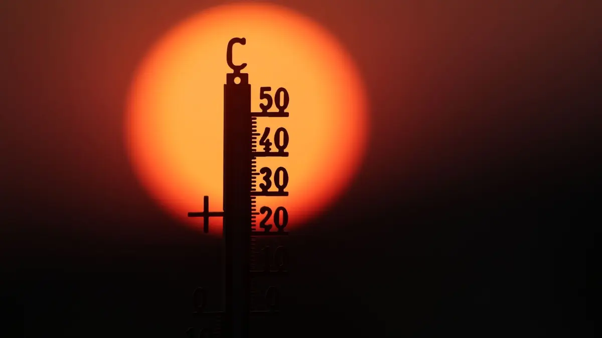 Hitze im Saarland: ARCHIV - 21.06.2026, Baden-Württemberg, Unlingen: Hinter einem Thermometer geht am Morgen die Sonne auf. (zu dpa: «RKI: Hunderte Hitzetote dieses Jahr im Saarland») Foto: Thomas Warnack/dpa +++ dpa-Bildfunk +++