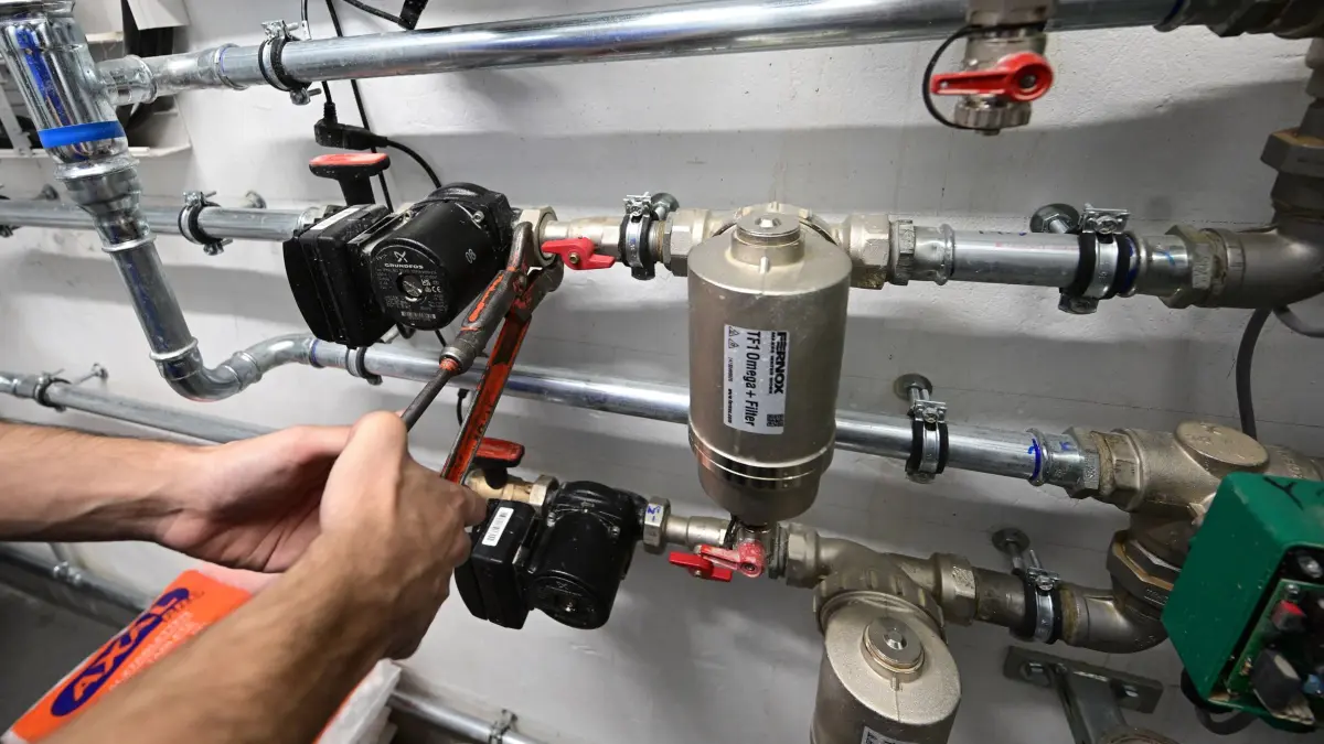 Handwerker: ARCHIV - 05.09.2023, Baden-Württemberg, Plankstadt: Ein Mitarbeiter in einem Handwerksbetrieb für Heizungsbau arbeitet in einem Heizungskeller an der Installation der Technik für eine Wärmepumpe. (zu dpa: «Abstimmung im Bundestag: Was sich beim Heizen jetzt ändert») Foto: Bernd Weißbrod/dpa +++ dpa-Bildfunk +++