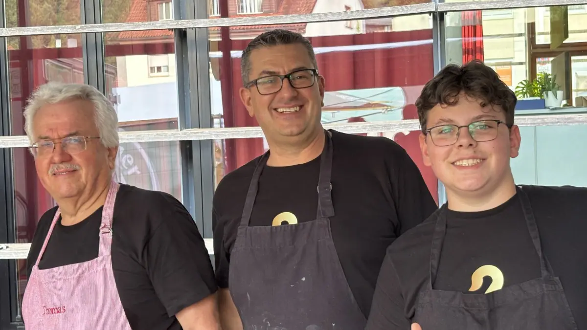 Thomas, Philipp und Eduardo Kaiser bereiten in der Küche Gyros zu.