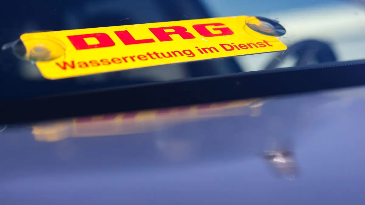 Wasserretter im Einsatz: ARCHIV - 10.05.2024, Nordrhein-Westfalen, Minden: In einem Fahrzeug ein Schild der DLRG «Wasserrettung im Einsatz» in der Windschutzscheibe eines PKW bei der Katastrophenschutzübung 2024 DLRG NRW. (zu dpa: «Frau mit Schwimmring verletzt sich in Ruhr - Gerettet») Foto: Christoph Reichwein/dpa +++ dpa-Bildfunk +++