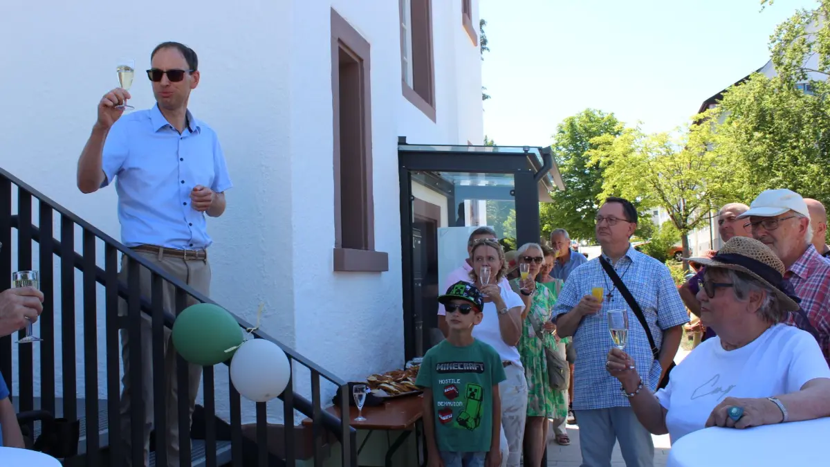 Mit vielen Gästen, darunter auch Pfarrer Marcus Maria Gut von der Seelsorgeeinheit „An der Eschach“, konnte Bürgermeister Torben Dorn auf das gelungene Projekt „Vom Pfarrhaus zum Vereins- und Kinderhaus" mit einem Glas Sekt anstoßen.