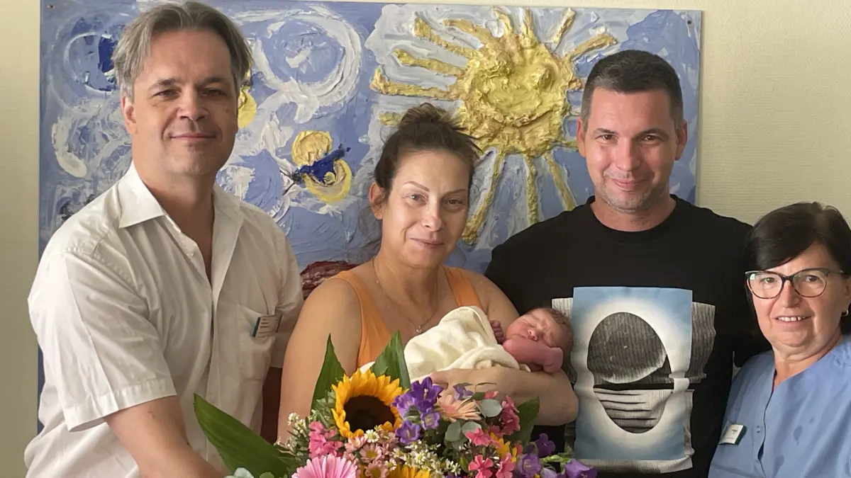 Emike Bodor (rechts) und Prof. Dr. Michael Bohlmann (links) gratulieren Nikoletta und Marton Komlósi zur Geburt von Flora.