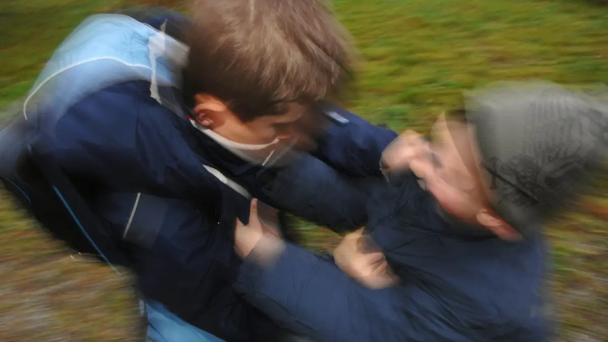 Symbolbild - Zwei Jungen raufen sich auf ihrem Schulweg: ILLUSTRATION - Kommt es zu Raufereien auf dem Schulhof, sollten Eltern alle beteiligten Seiten hören. (zu dpa: «Schulkonflikte lösen: Ruhig bleiben, alle Seiten hören») Foto: Armin Weigel/dpa/dpa-tmn - Honorarfrei nur für Bezieher des dpa-Themendienstes +++ dpa-Themendienst +++