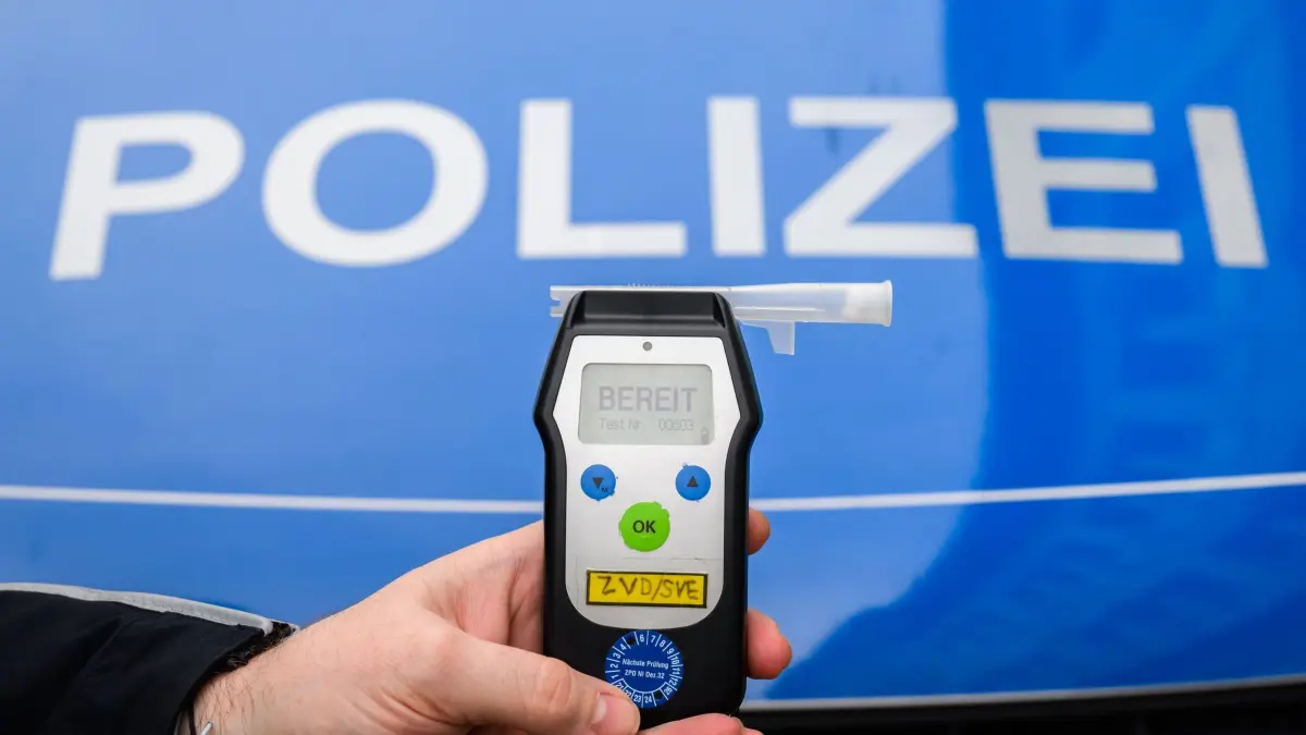 Mit 2,53 Promille schwimmen: ARCHIV - 28.01.2025, Niedersachsen, Hannover: ILLUSTRATION - Ein Polizist zeigt einen Alkoholtest (Atemtest), mit dem Verkehrsteilnehmer auf ihre Fahrtüchtigkeit hin überprüft werden können (gestellte Szene). (zu dpa: «Große Suche nach Schwimmer – der längst Zuhause war») Foto: Julian Stratenschulte/dpa +++ dpa-Bildfunk +++