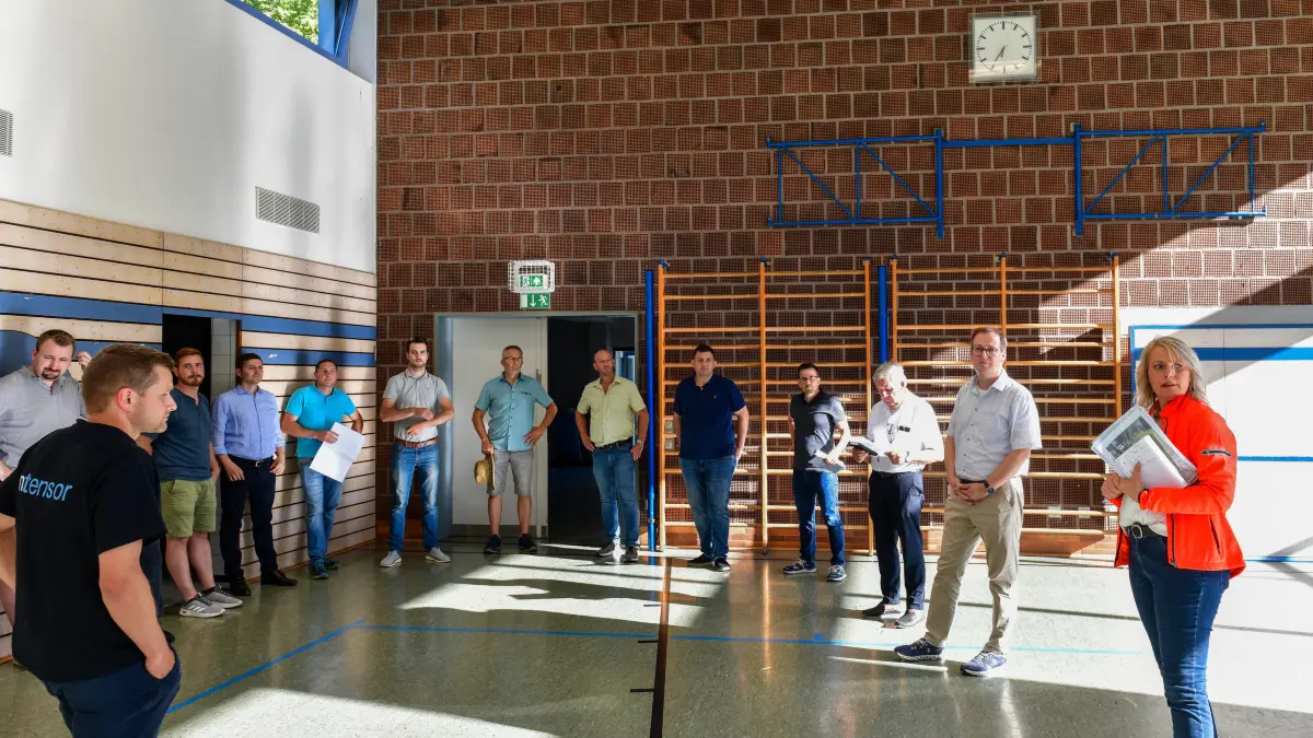 Im Visier des abendlichen Ortsbegangs 2026: In der sonnenlichtdurchfluteten Schlichemhalle machen sich der Tieringer Ortschaftsrat mit Ortsvorsteherin Isabella Merkt, Bürgermeister Frank Schroft und weitere Vertreter der Stadtverwaltung Gedanken über die Sanierung dieses Sport- und Veranstaltungsgebäudes.