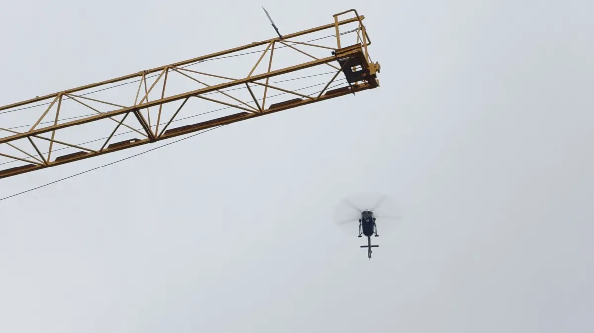 Direkt über der Innenstadt – unweit des Krans für die Rathaus-Baustelle – steht der Hubschrauber am Himmel.