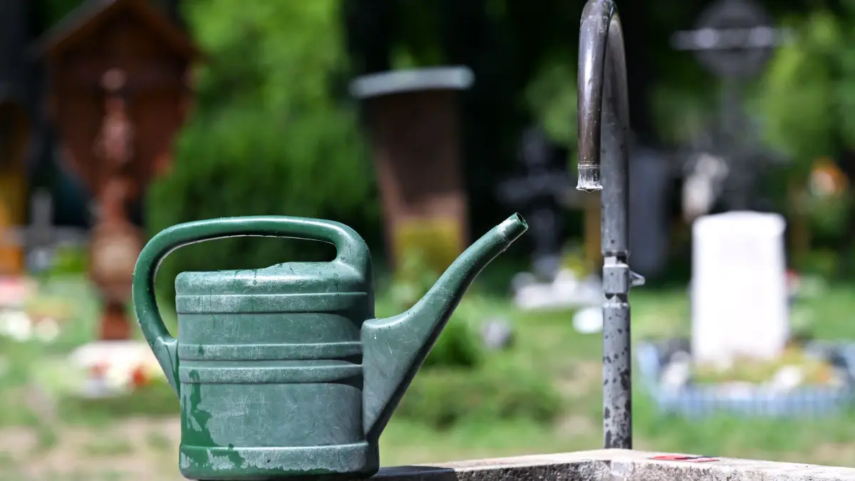 Wassersparen in München: 16.07.2026, Bayern, München: Eine Gießkanne steht auf einem Friedhof. Hitze und Trockenheit lassen in München den Wasserverbrauch steigen. Die Stadt reagiert mit konkreten Verboten. Foto: Sven Hoppe/dpa +++ dpa-Bildfunk +++