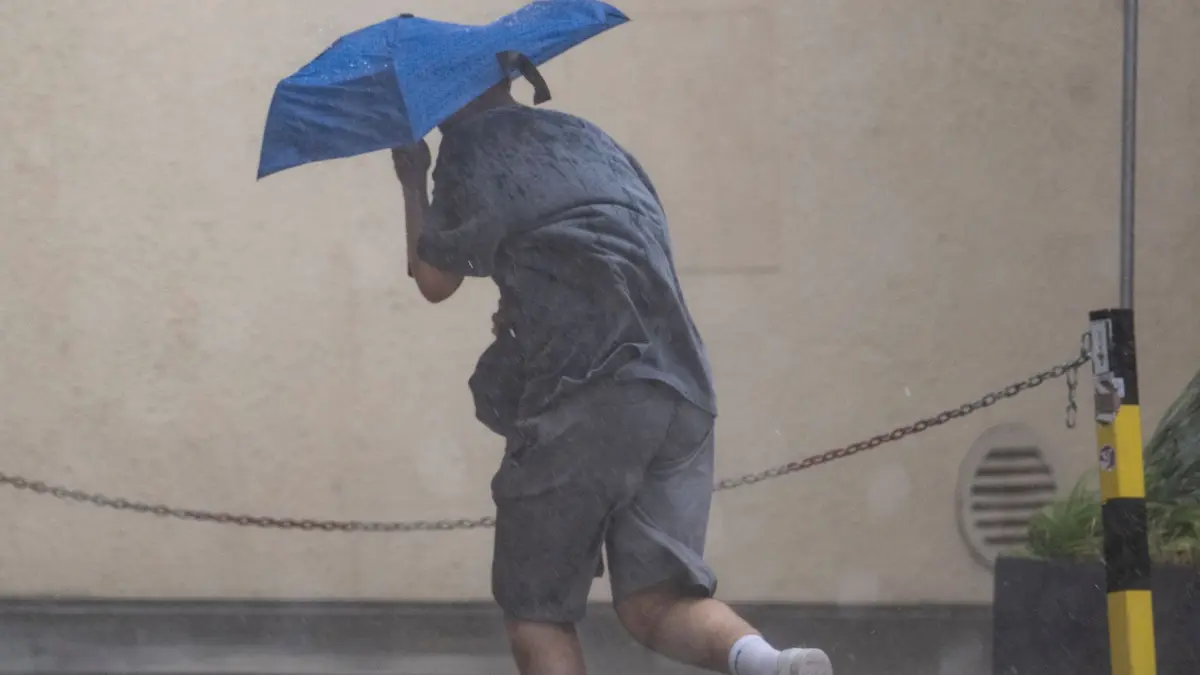 Regenwetter in Stuttgart: 17.07.2026, Baden-Württemberg, Stuttgart: Ein Mann rennt in Stuttgart durch starken Regen und versucht sich, mit einem Regenschirm zu schützen. Foto: Marijan Murat/dpa +++ dpa-Bildfunk +++