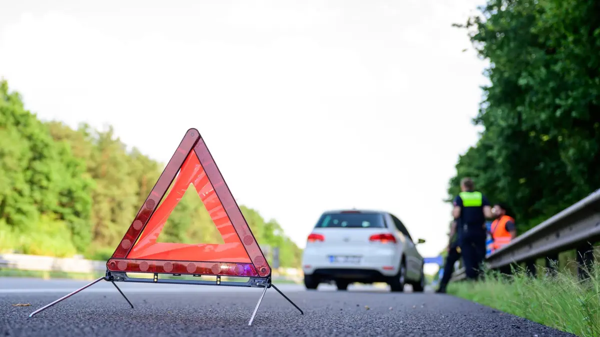 Autobahnpolizei im Einsatz: PRODUKTION - 02.07.2025, Niedersachsen, Maschen: Mit einem Warndreieck ist ein liegengebliebenes Fahrzeug auf der Autobahn abgesichert. (zu dpa: «Lkw-Reifen platzt auf der A4 – drei Autos beschädigt») Foto: Philipp Schulze/dpa +++ dpa-Bildfunk +++