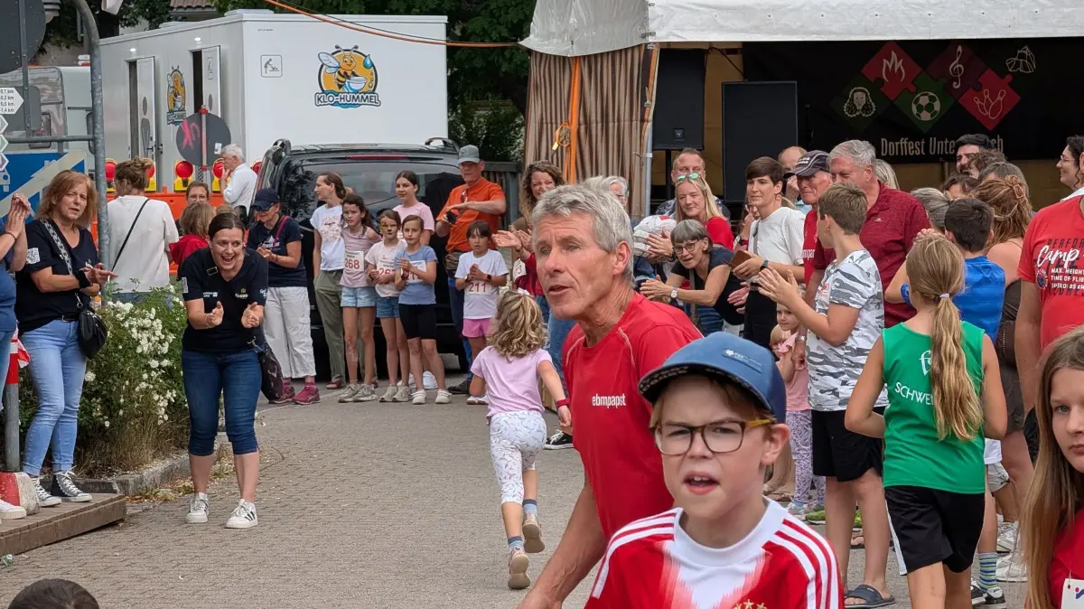 Beim Zieleinlauf der Bambini feuern die Zuschauer die Läufer an.