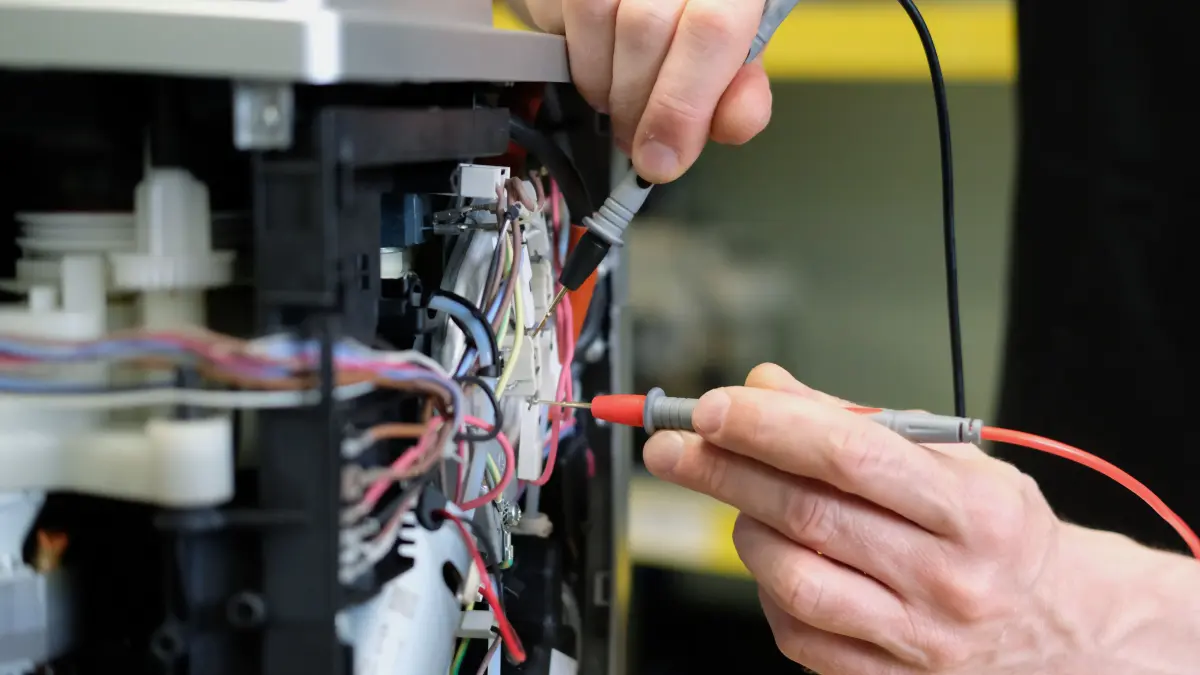 An einem Kaffee-Vollautomaten in einer Reparaturwerkstatt werden elektronische Messgrößen ermittelt.