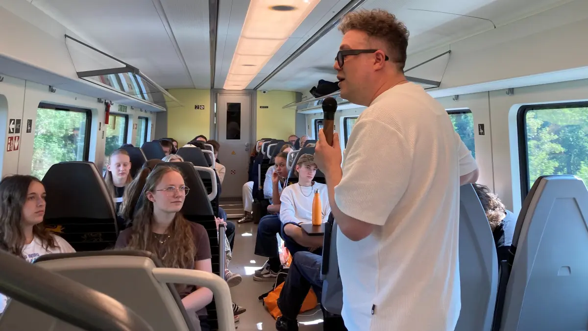 BookToker Thomas Sachsenmaier führt durch die Unterrichtsstunde in der Bahn.