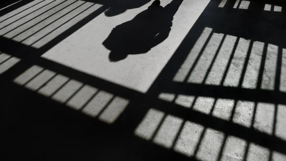 Gefängnis U-Haft Untersuchungshaft Symbolfoto Schwabo OV LZ ARCHIV - 19.09.2013, Baden-Württemberg, Ravensburg: Der Schatten eines Mannes ist in der Justizvollzugsanstalt in einer Tür zu sehen. (zu dpa: «16-Jähriger sitzt nach Schüssen auf Polizisten in U-Haft») Foto: Felix Kästle/dpa +++ dpa-Bildfunk +++