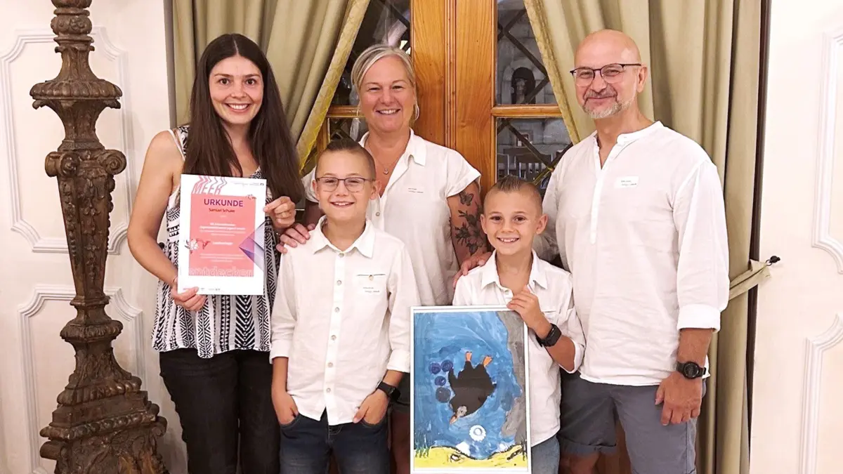 Samuel Schuler (mit Bild) mit der Familie während der Preisverleihung, links Alina Ernst von der Volksbank Deisslingen.