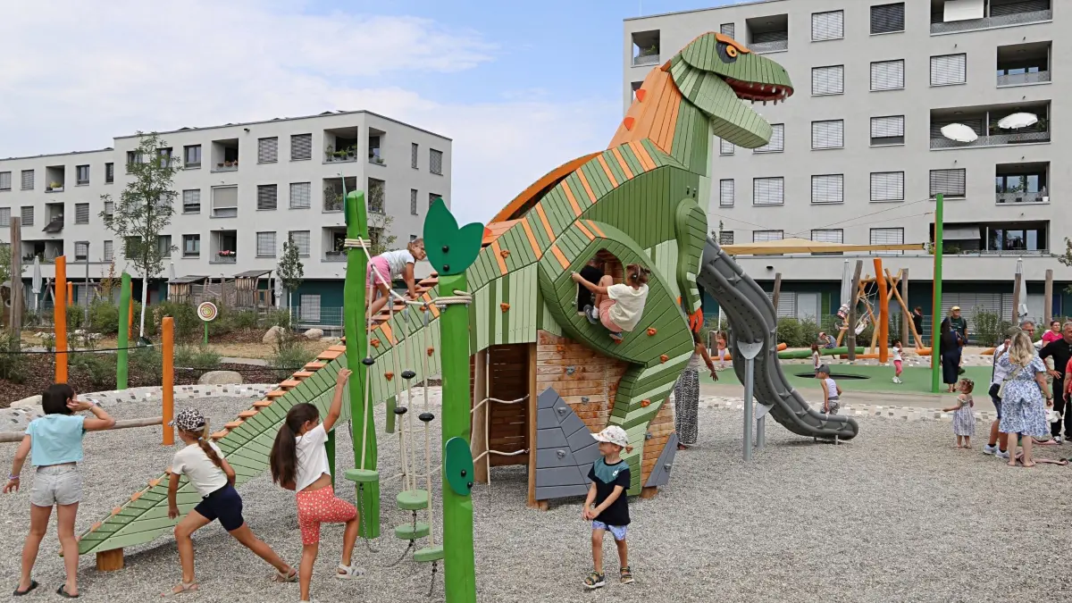 Kinder klettern und rutschen am Dino.