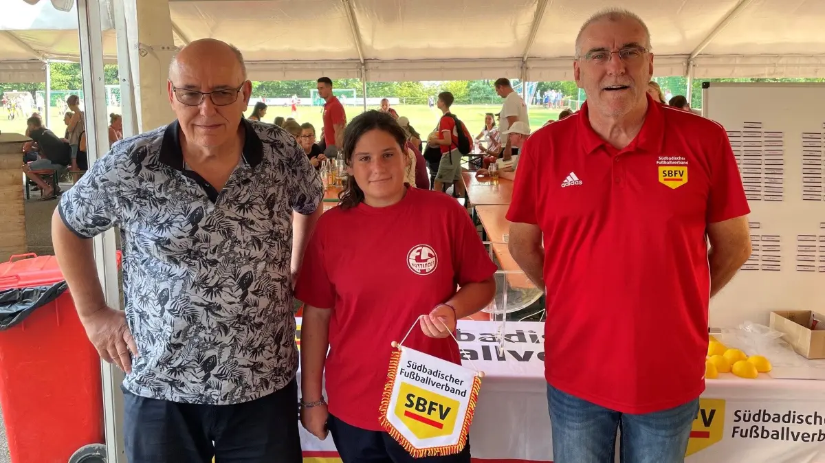 Bezirksvorsitzender Uwe Sütterlin (von links), Losfee Aurelia Coscia und Pokalverantwortlicher Hanspeter Stein führten die Losung in Huttingen durch.